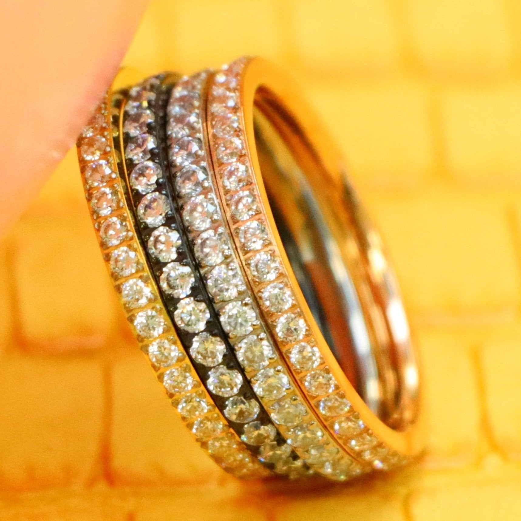 2mm Men's Titanium Black/Silver/Yellow Gold/Rose Gold Full Eternity CZ Rings supported with a finger from left side