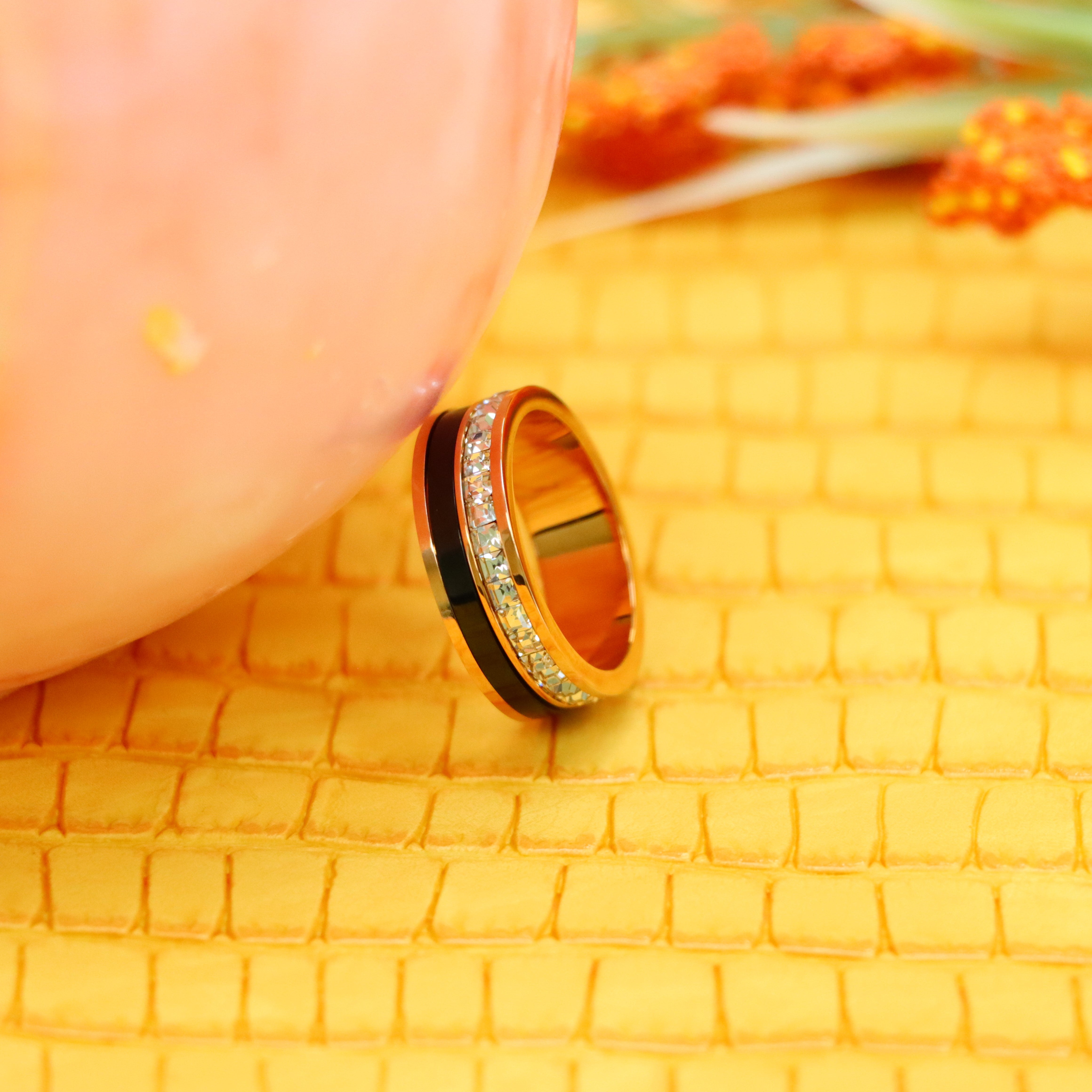 7mm Rose Gold Black IP Plated Titanium Spinner Princess cut Eternity CZ Titanium Ring supported with a finger from left side - Rose Gold ring for women and men
