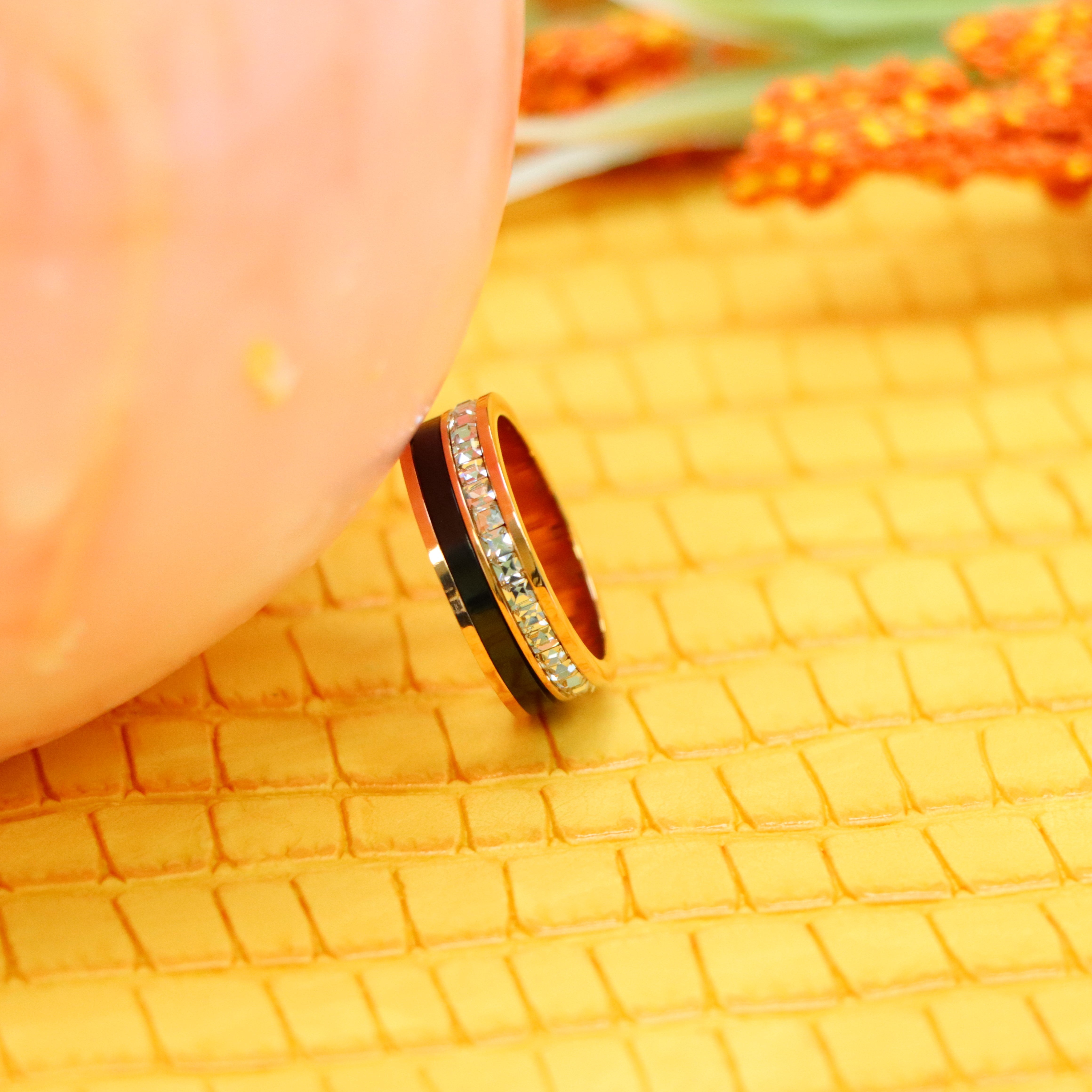 7mm Rose Gold Black IP Plated Titanium Spinner Princess cut Eternity CZ Titanium Ring clear view supported with a finger from left side - Rose Gold ring for women and men