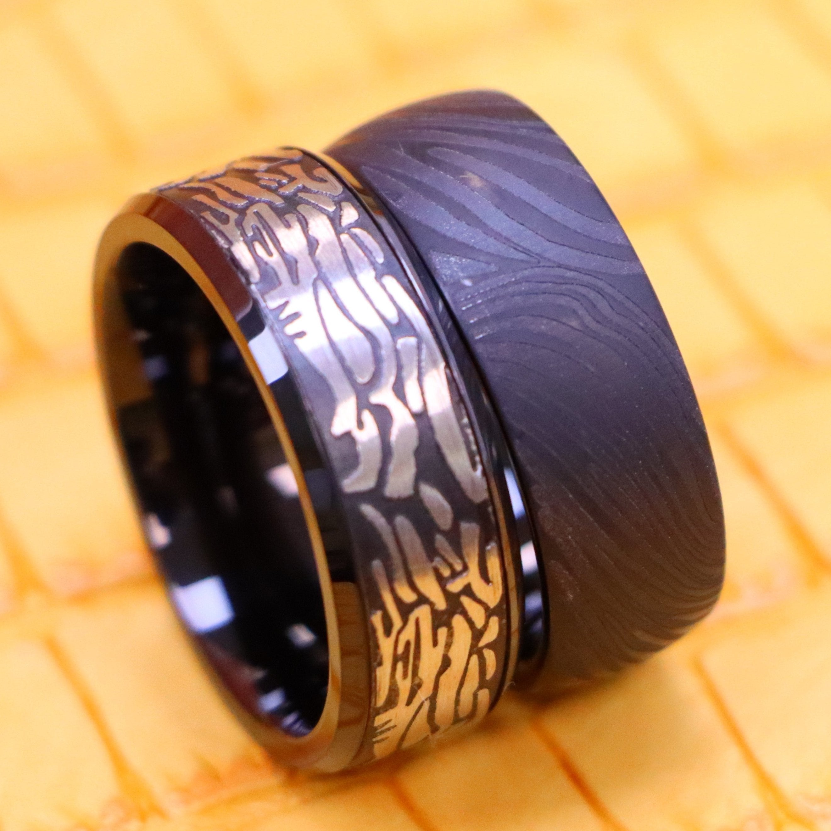 8mm Black IP Plated Semi-Dome Laser Carved Mokume Gane Effect (wood grain effect) Tungsten Ring and 8mm Black IP Plated Laser Carved Rock Art Pattern Tungsten Ring for bold men and women - clear front view
