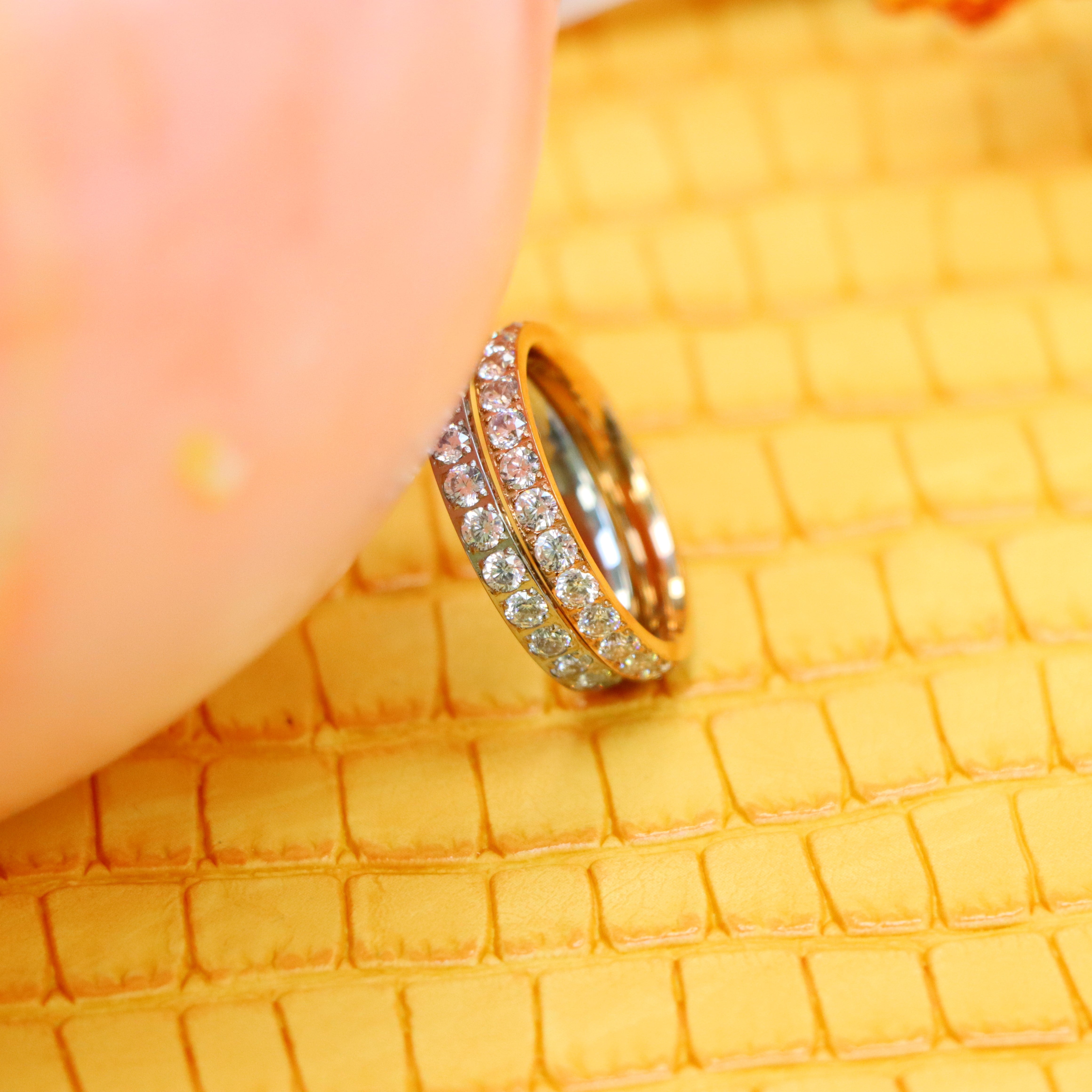 3mm White and Rose Gold Full Eternity White CZ Titanium Rings supported with a finger from left side zoom out view